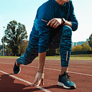 man-runner-stretching-legs-preparing-run-training-stadium-tracks-doing-warm-up